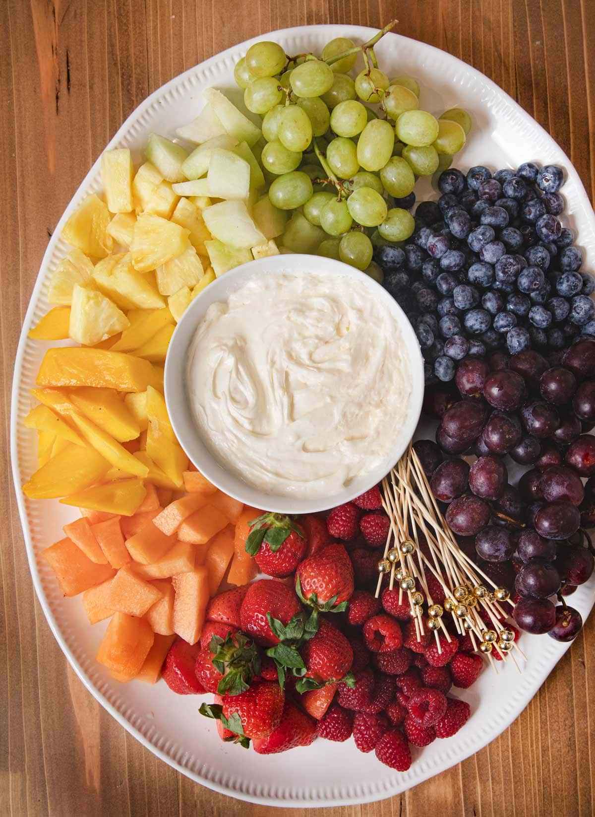 Fruit Dip in bowl in center of serving platter with rainbow fruit