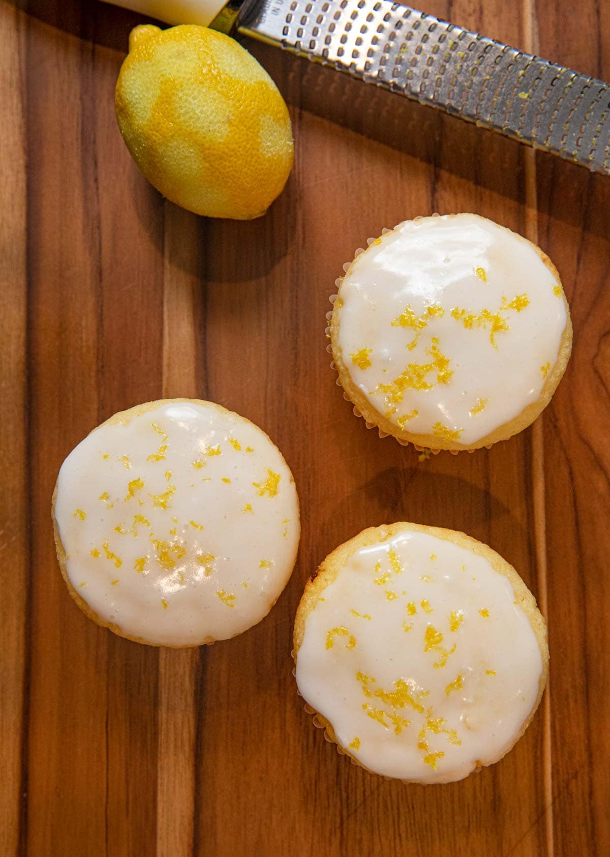 top-down view of Iced Lemon Muffins with zested lemon