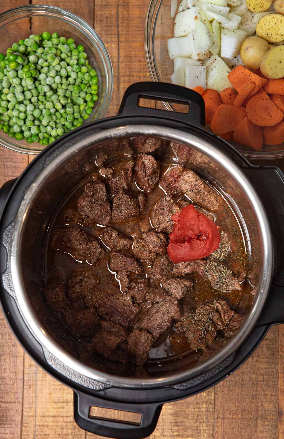 Instant Pot Beef Stew ingredients in bowls with beef in pot