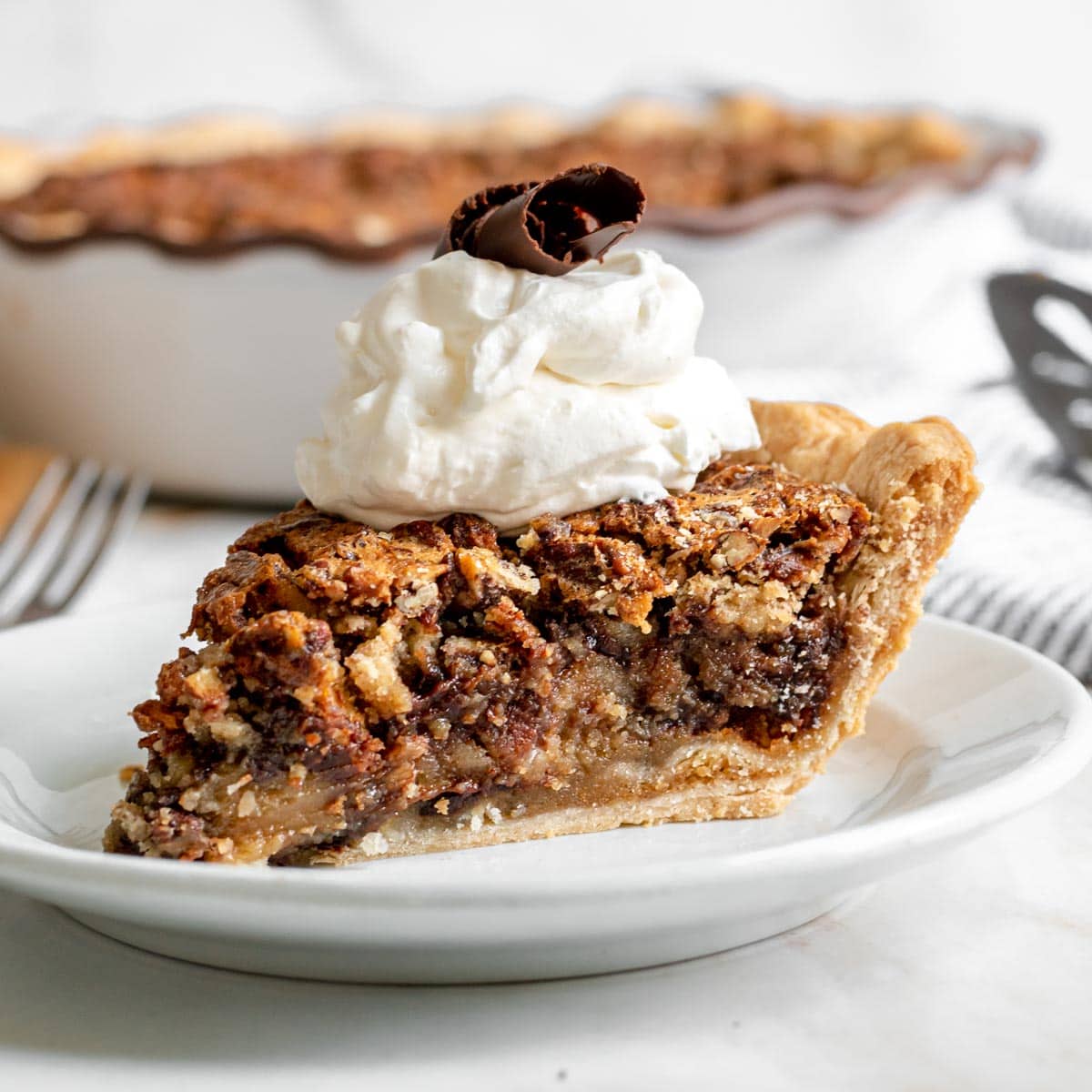 Kentucky Derby Pie slice on plate with whipped cream