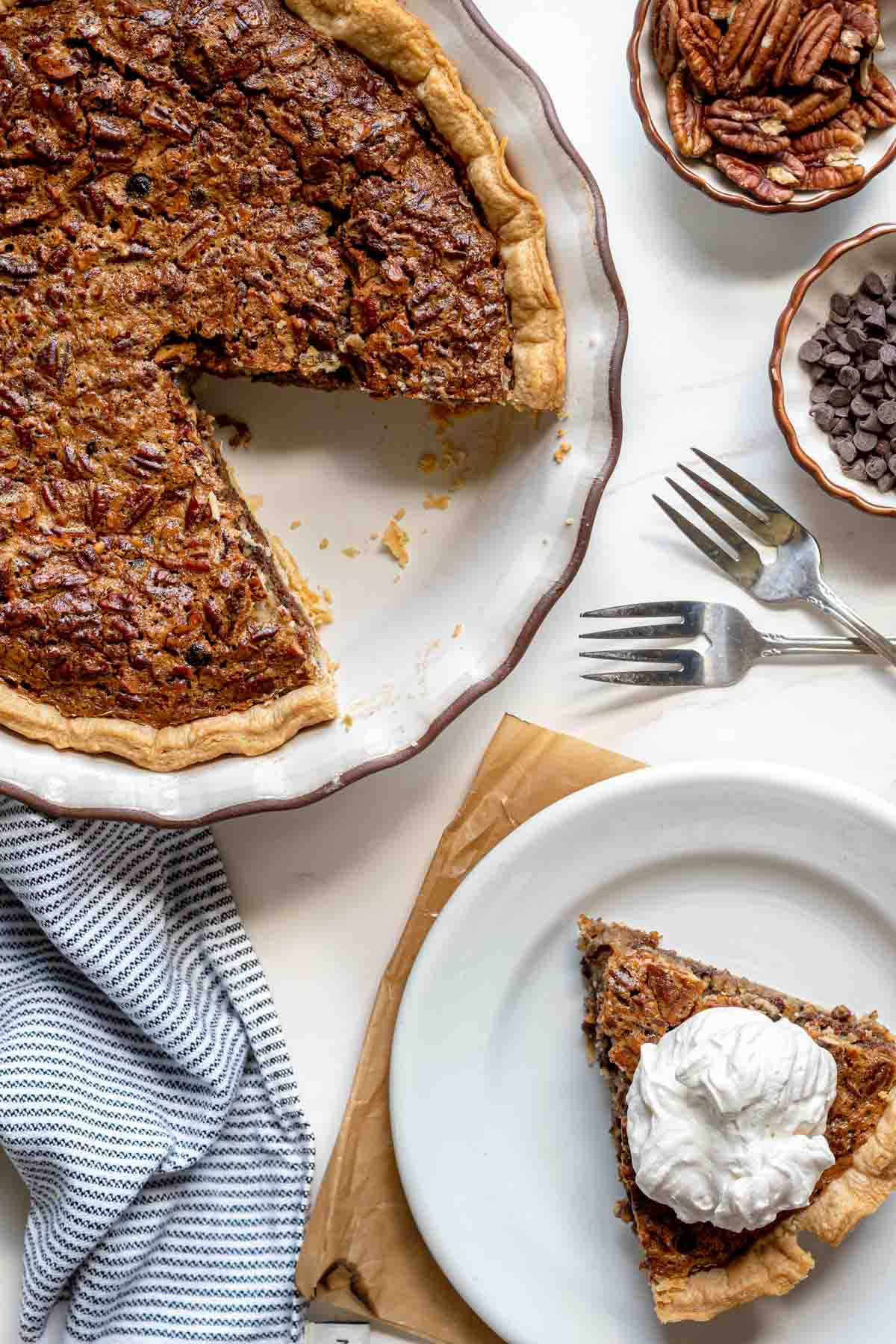 Kentucky Derby Pie with slice removed in pie dish and slice on plate with whipped cream