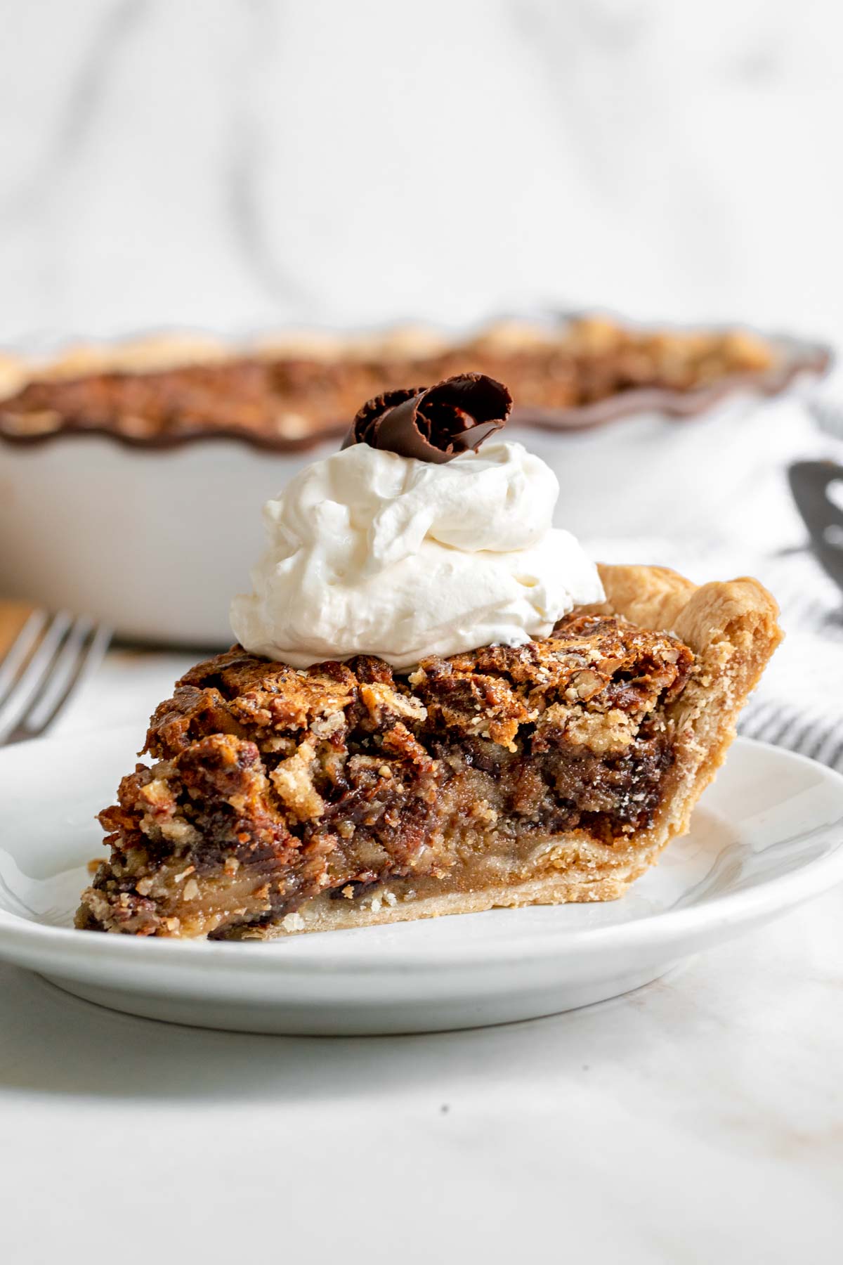 Kentucky Derby Pie slice on plate with whipped cream