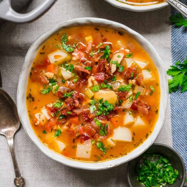 Manhattan Clam Chowder in bowl with bacon and parsley garnish