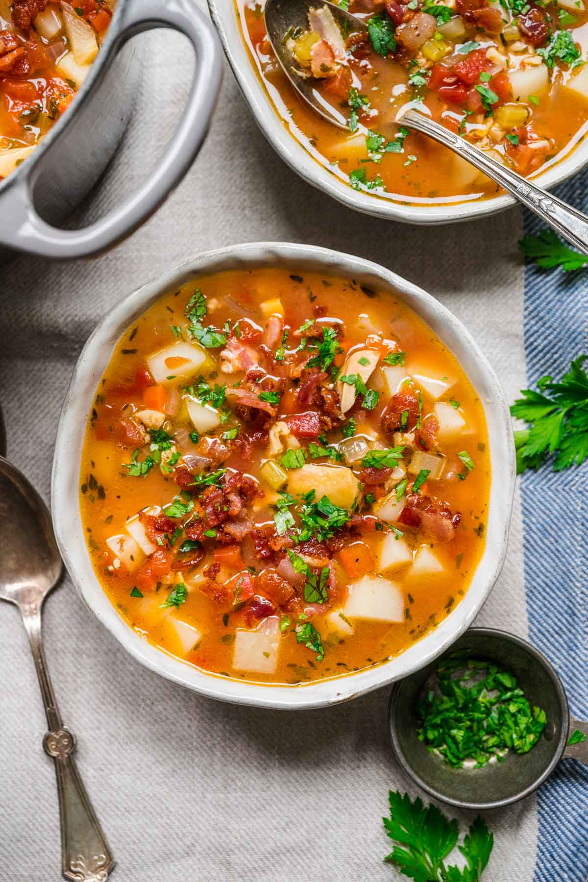 Manhattan Clam Chowder in bowl with bacon and parsley garnish