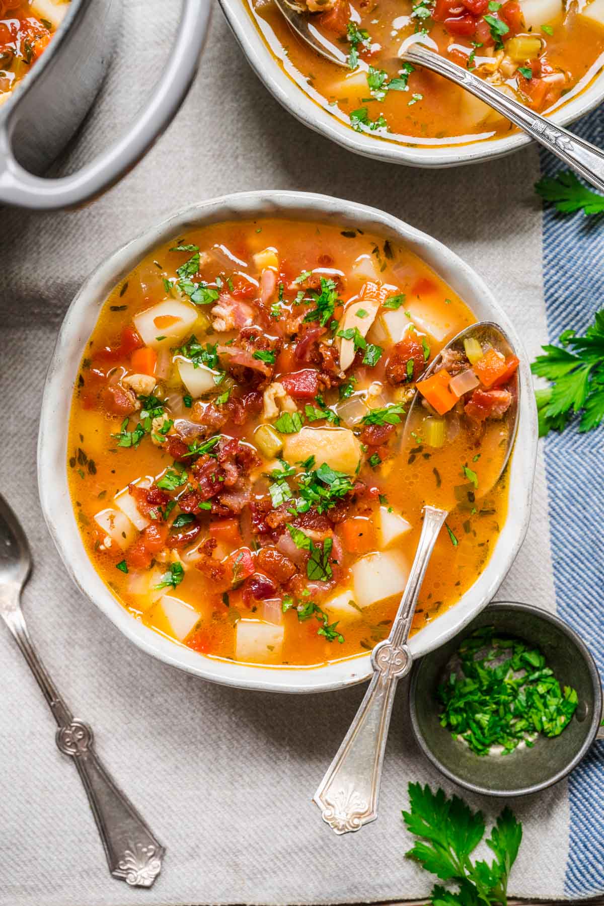 Manhattan Clam Chowder in bowl with bacon and parsley garnish