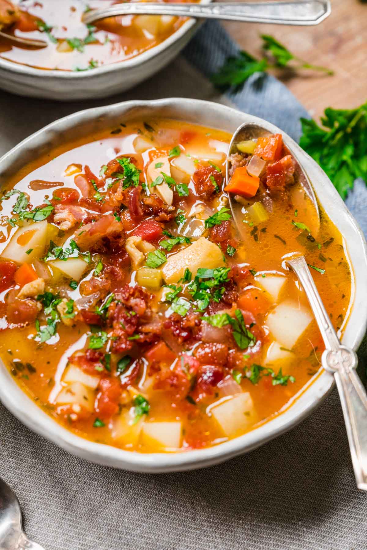 Manhattan Clam Chowder in bowl with bacon and parsley garnish