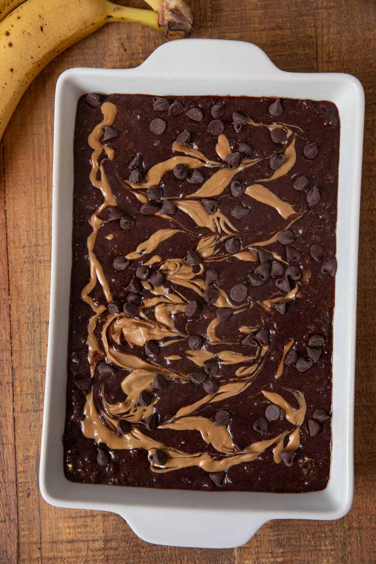Peanut Butter Chocolate Banana Brownies batter in baking dish with peanut butter swirl