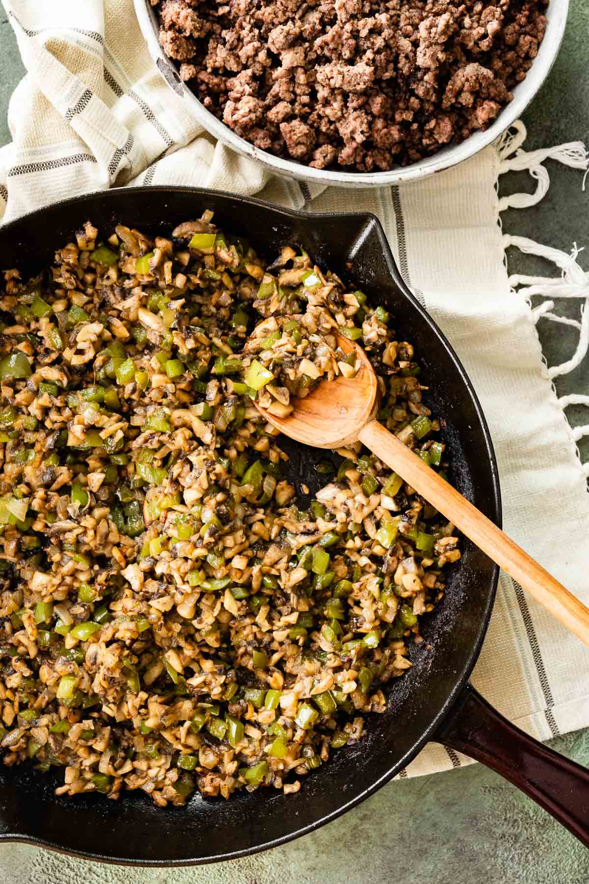 Cooked ground beef, onions, and bell peppers in skillet for Philly Cheesesteak Shepherd's Pie