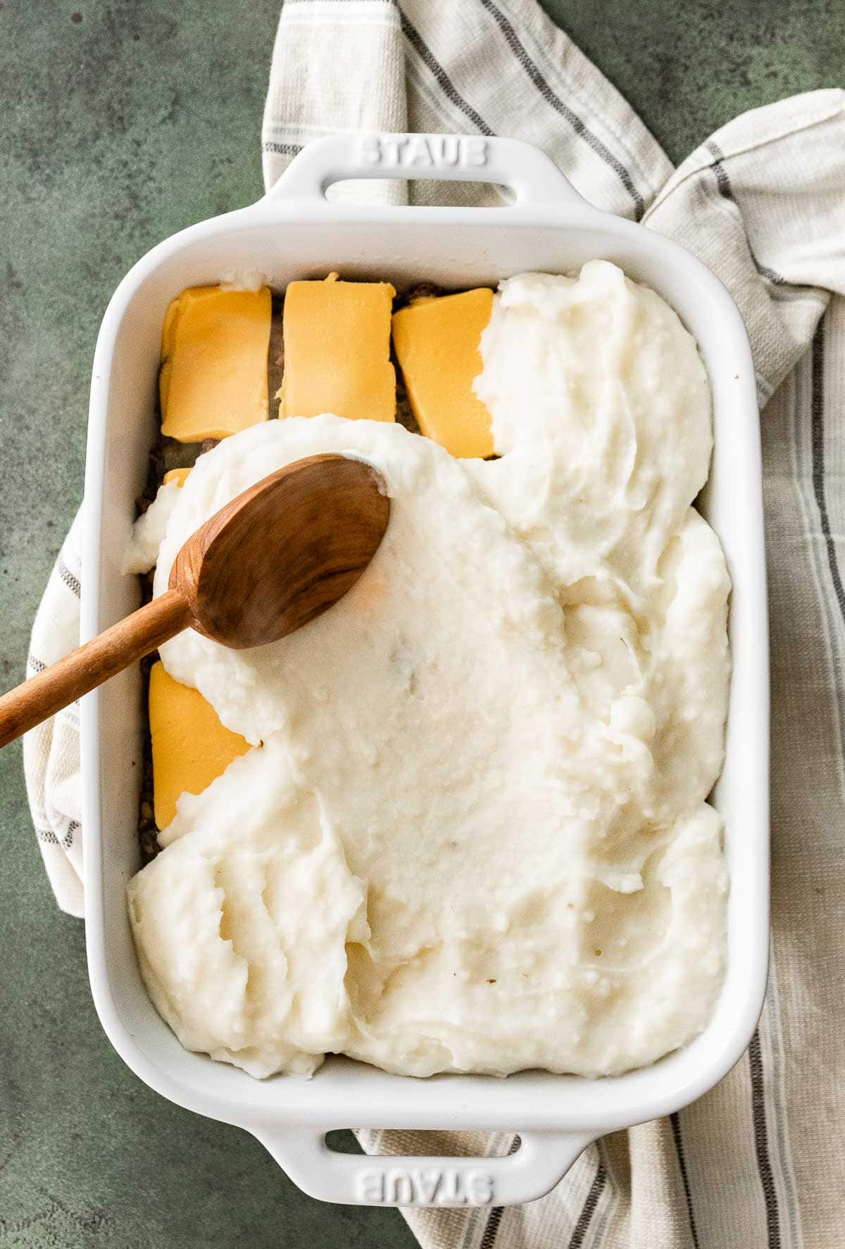 Assembling layers in baking dish for Philly Cheesesteak Shepherd's Pie