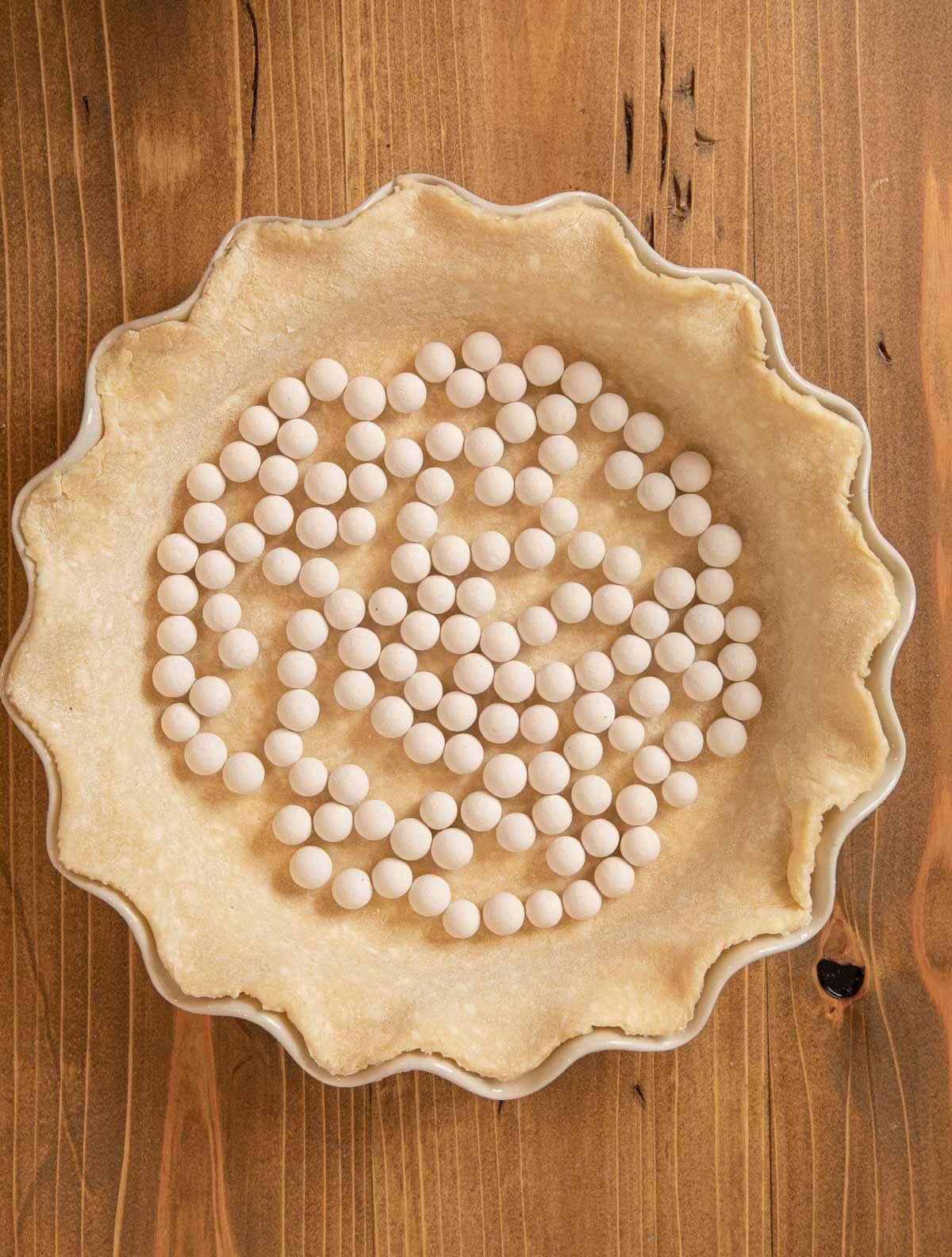 Pie Crust unbaked crust with pie weights on pie plate