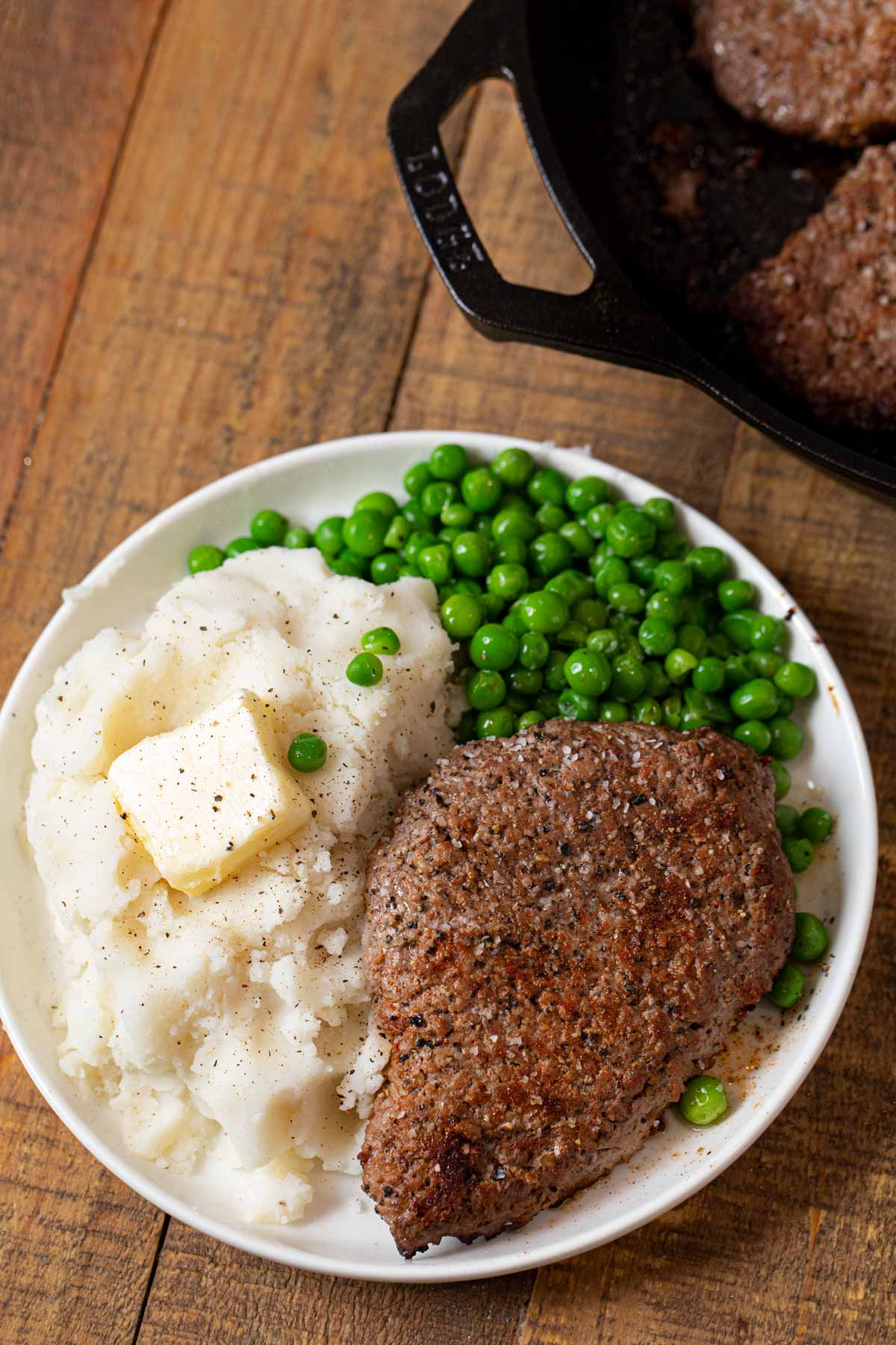 Seared Cube Steak on plate with mashed potatoes and peas
