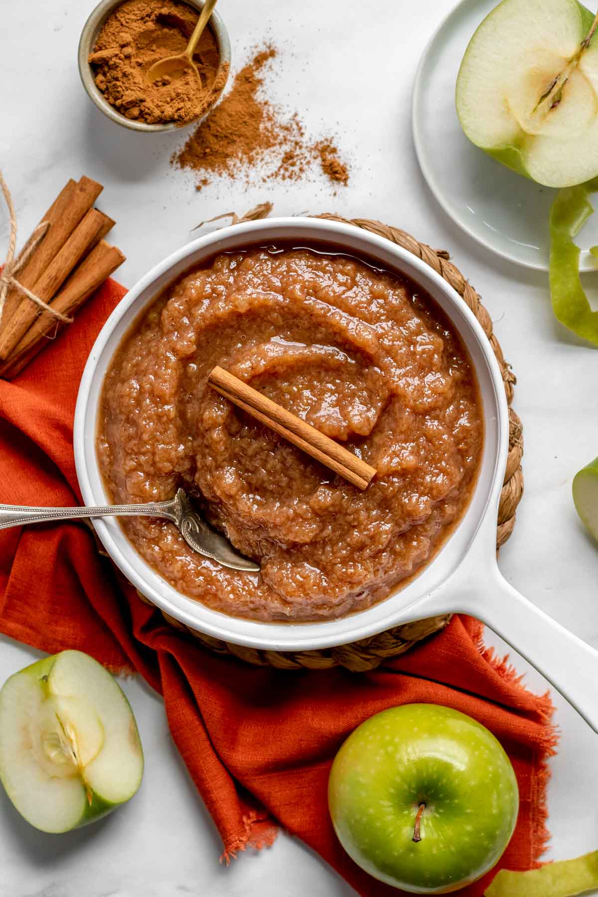 Slow Cooker Applesauce in serving dish with cinnamon stick and spoon