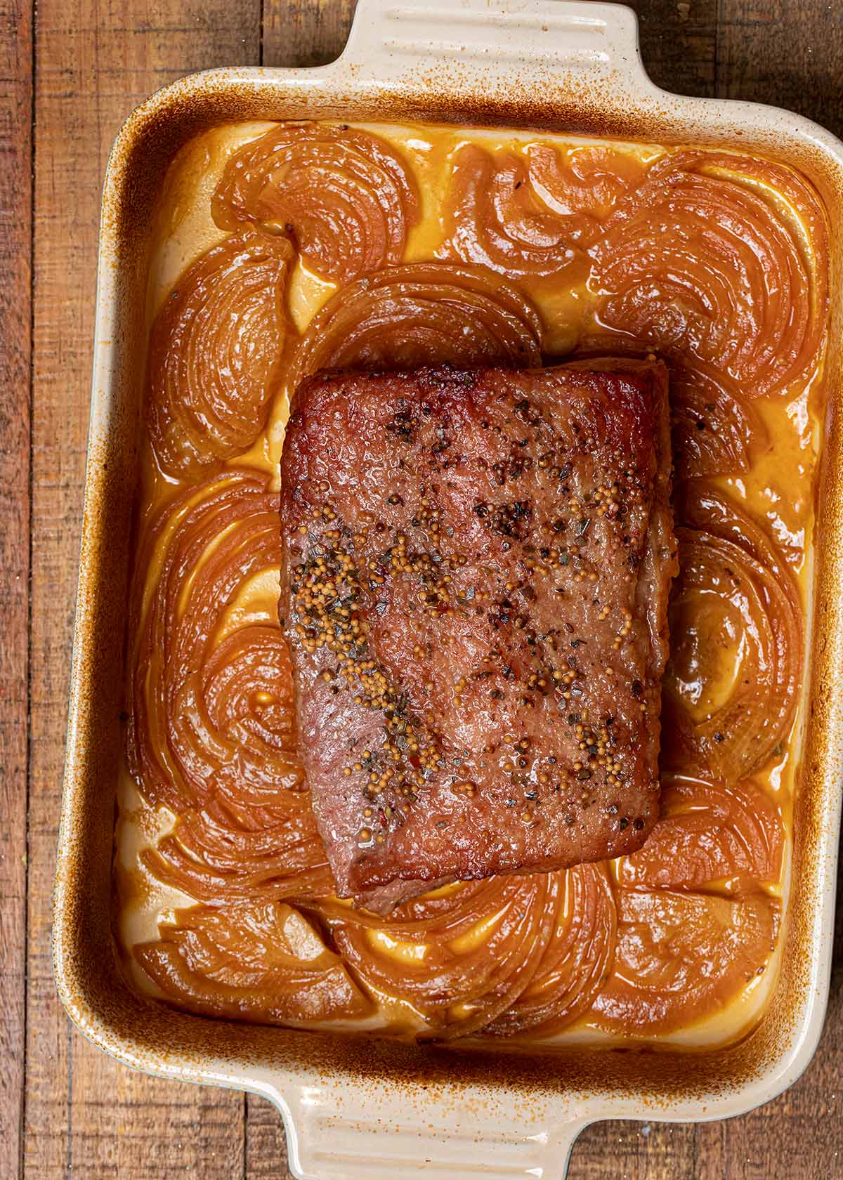 Braised Corned Beef in baking dish with caramelized onions