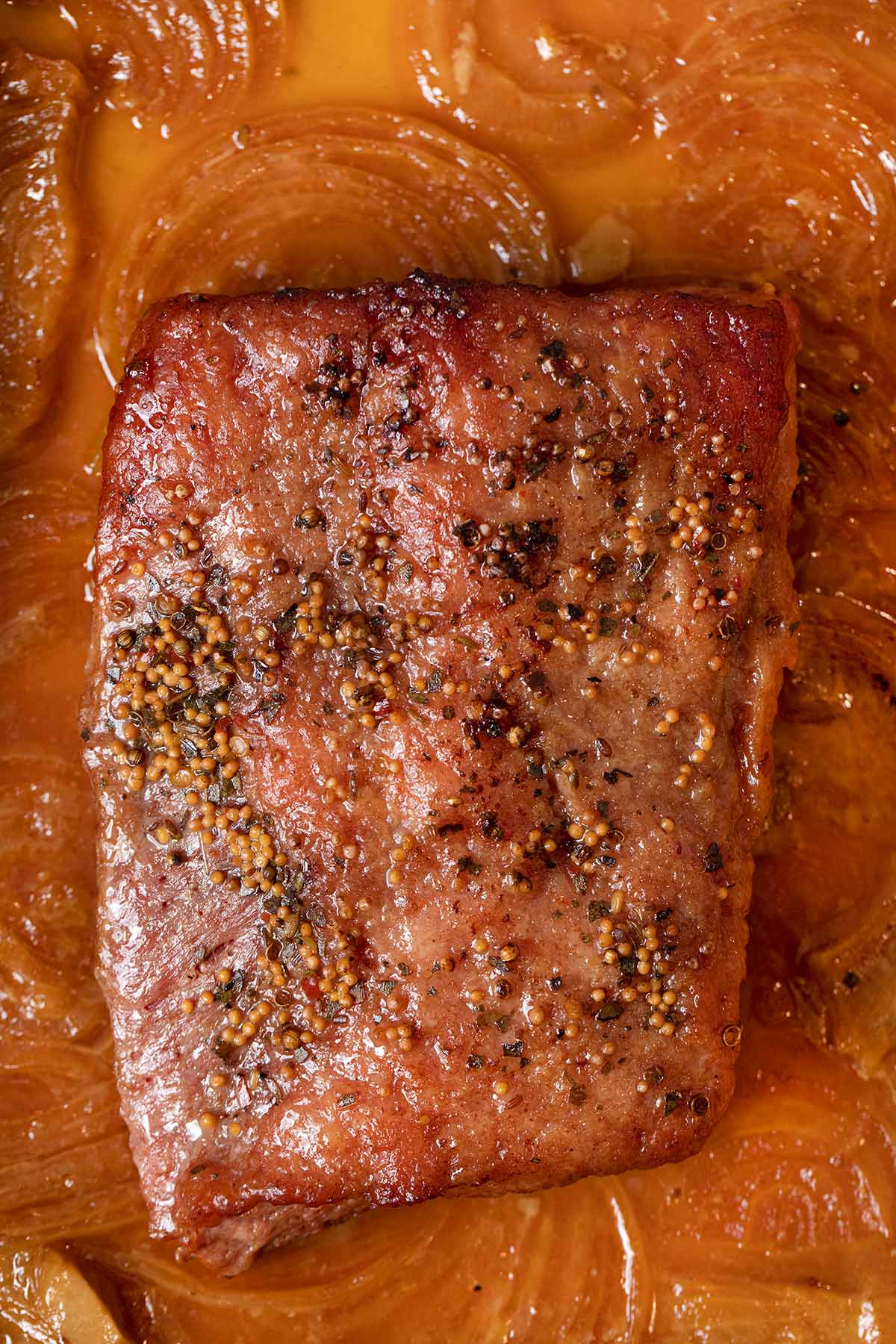 Braised Corned Beef in baking dish with caramelized onions