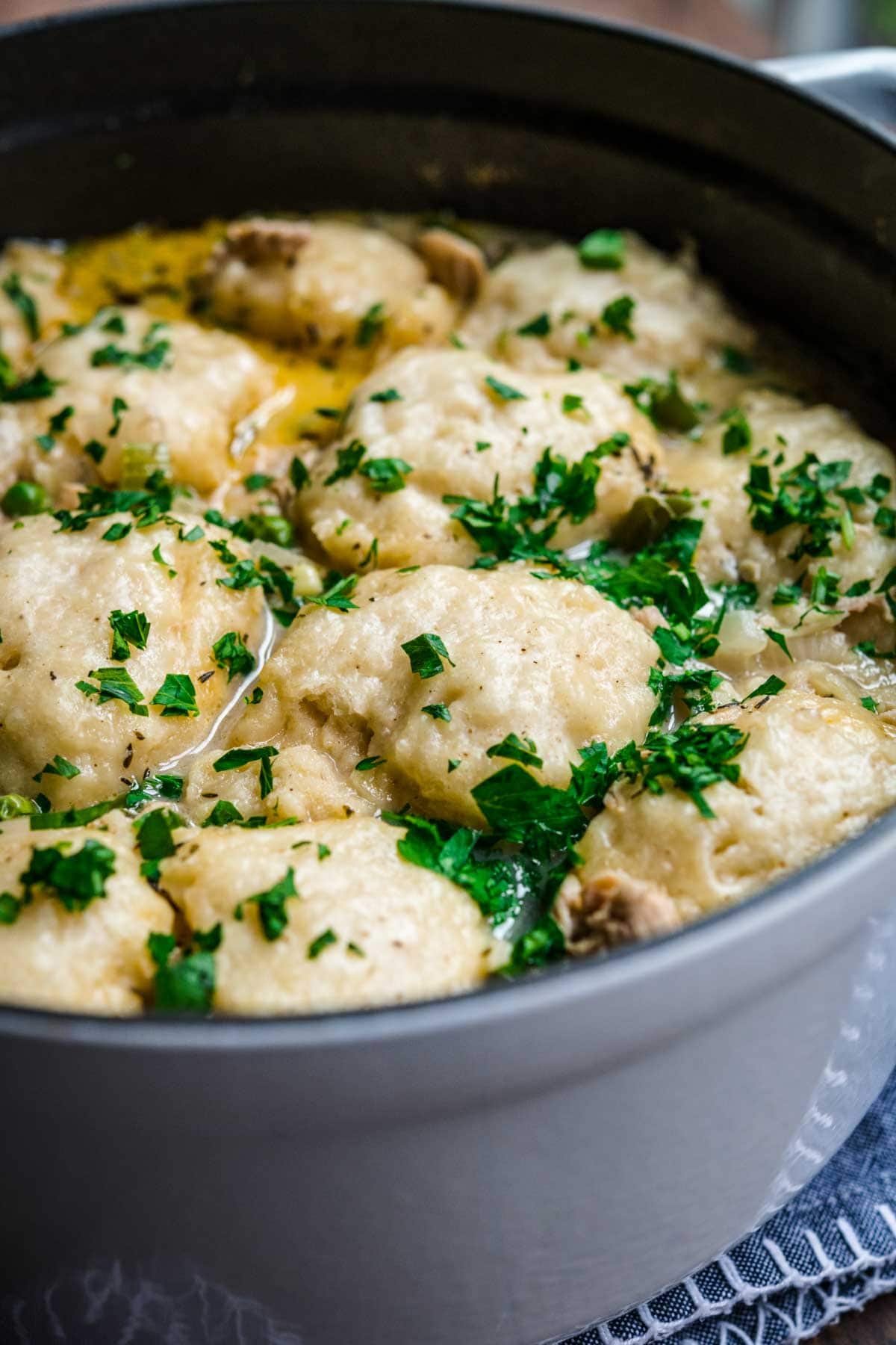 Chicken and Dumplings Soup in pot with parsley garnish