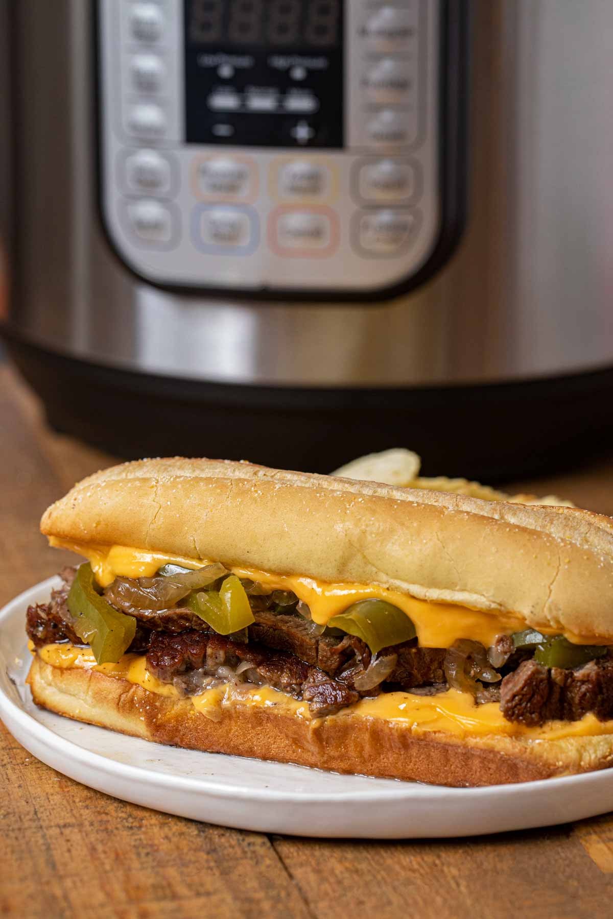 Instant Pot Philly Cheese Steak Sandwich on plate with cheese whiz