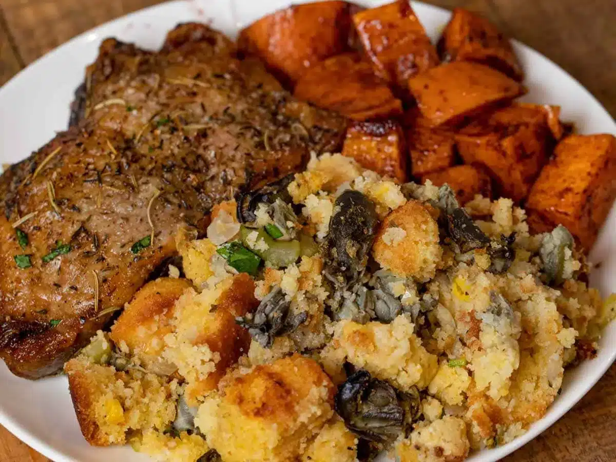 stuffing on a plate with meat and sweet potatoes 