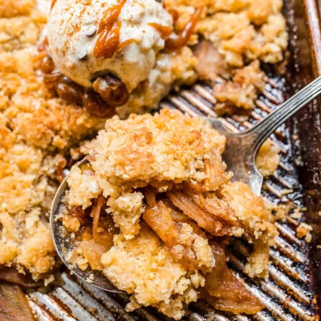 Sheet Pan Apple Crisp being served with ice cream and caramel.