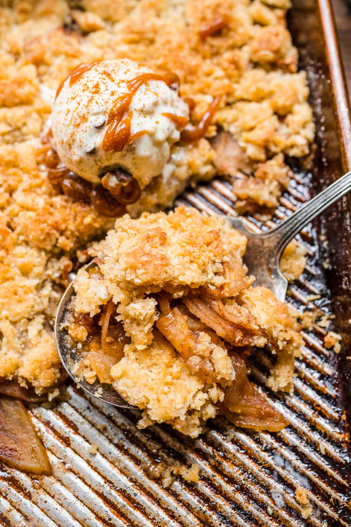 Sheet Pan Apple Crisp being served with ice cream and caramel.