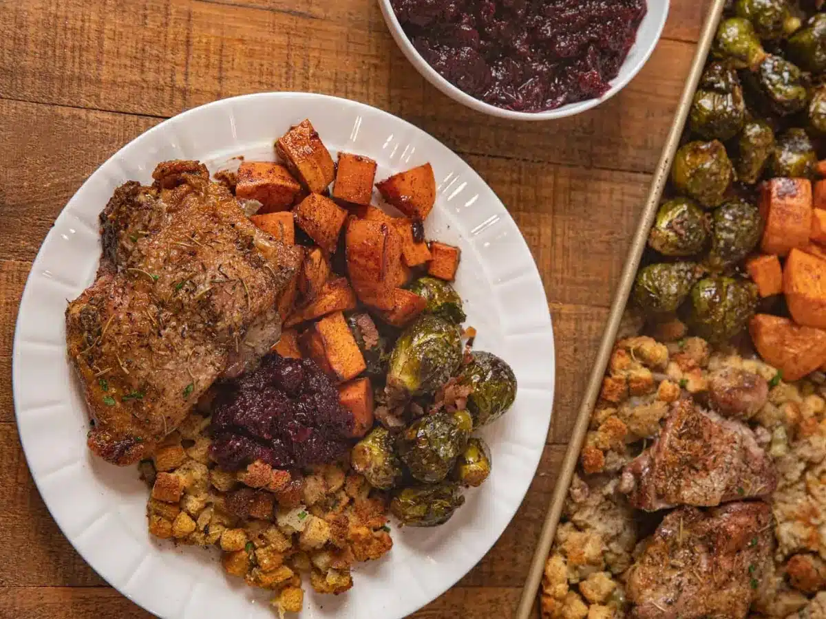 Sheet pan meal served on plan with pan and sauce