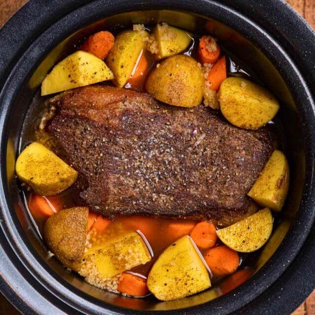 cooked whole roast in crockpot with carrots and potatoes