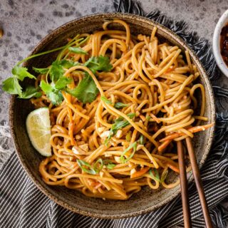 Spicy Peanut Noodles in serving bowls with chop sticks and cilantro lime garnish