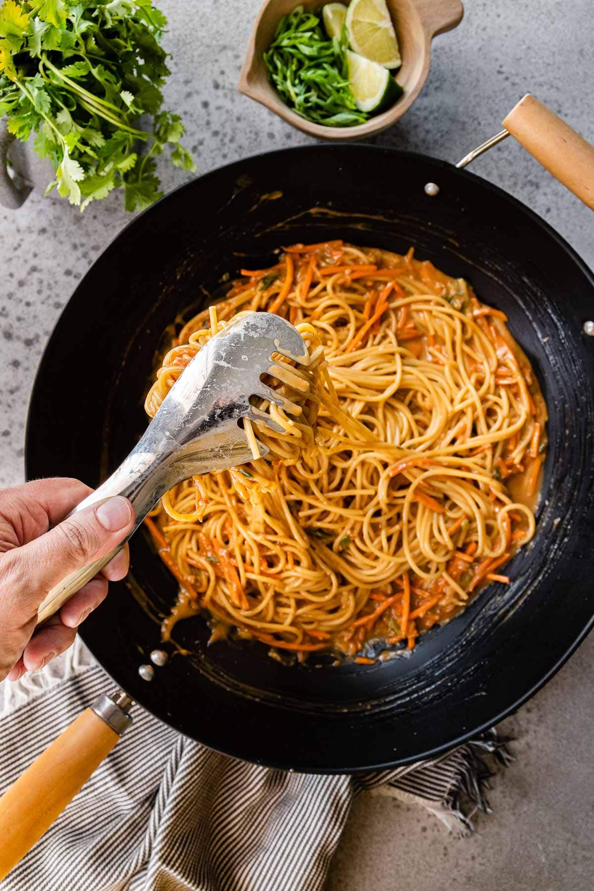 Mixing noodles and sauce in pan for Spicy Peanut Noodles