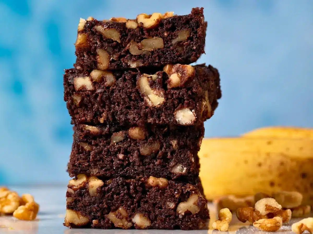fudgy dessert squares with nuts stacked on top of one another