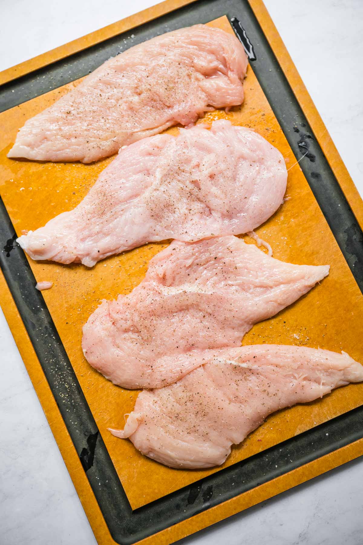 Chicken breasts on cutting board for Chicken Cordon Bleu