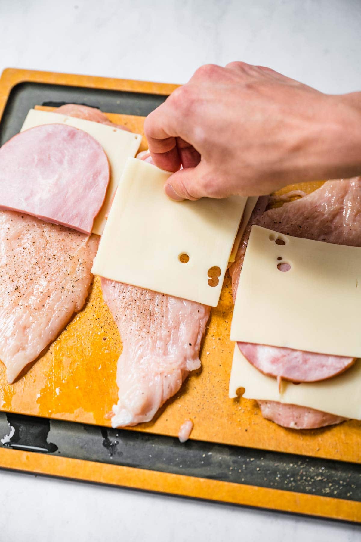 Ham and cheese slices on chicken breasts for Chicken Cordon Bleu