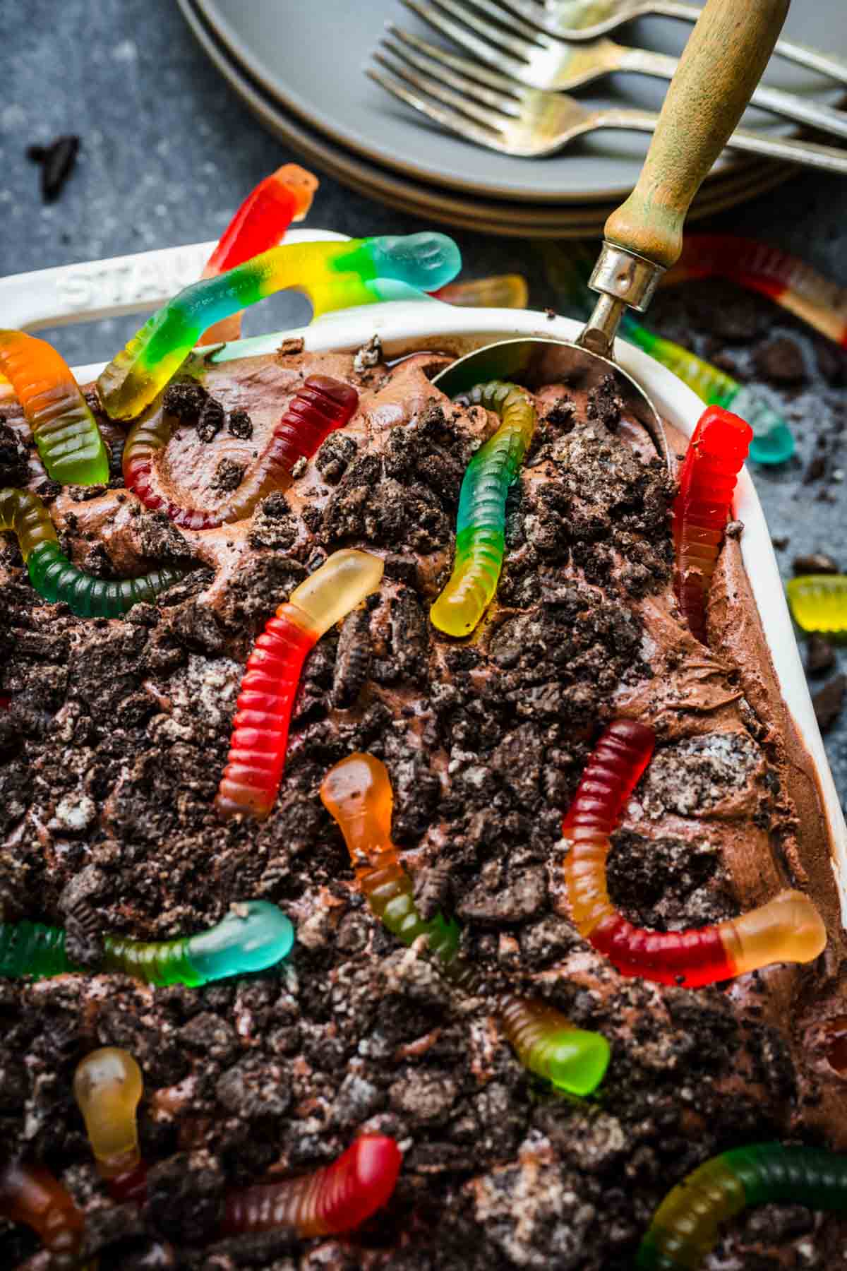 Chocolate Pudding Dirt Cake with pudding, crushed oreos, and gummy worms on top in baking dish