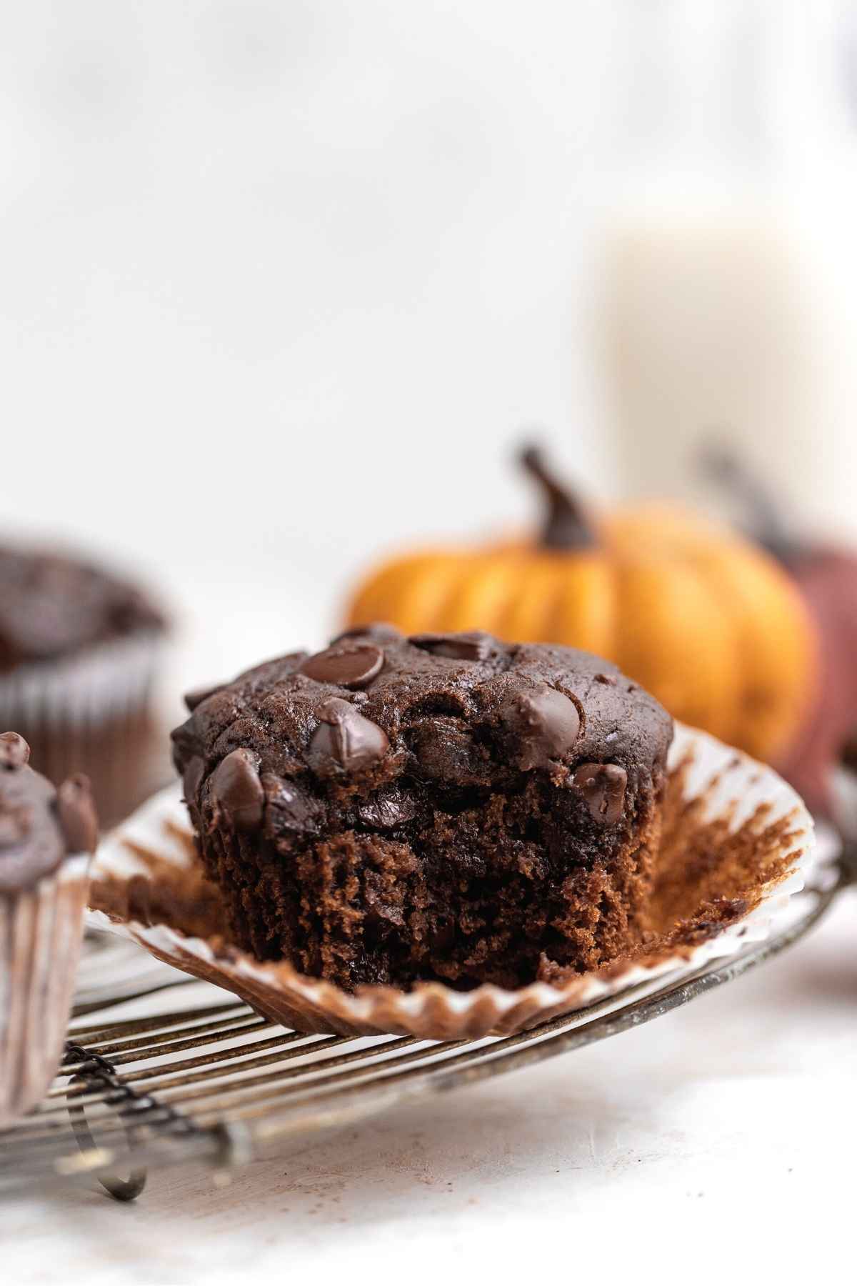 Chocolate Pumpkin Muffins on wire rack with bite taken