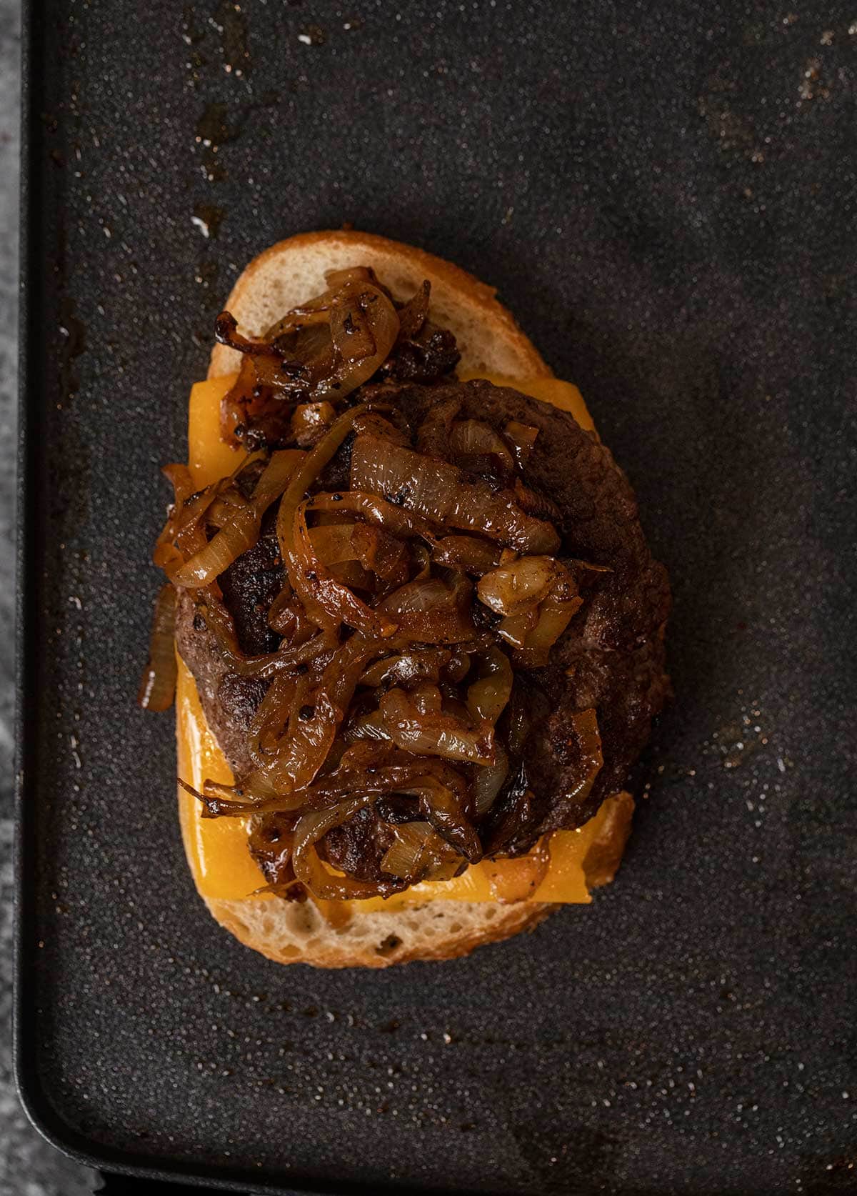 Classic Patty Melt bread, cheese, burger and caramelized onions on griddle