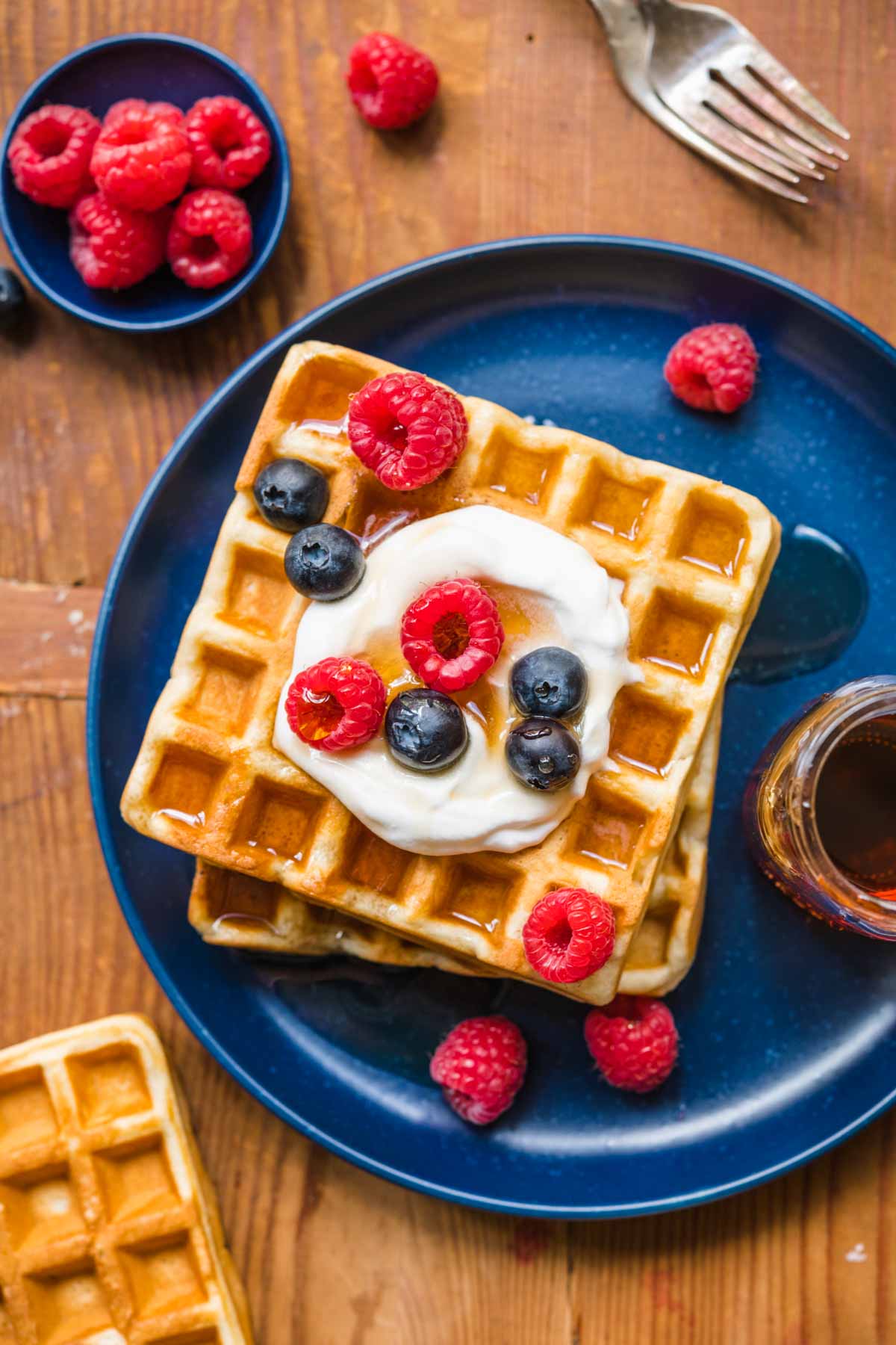 Classic Waffles on plate with whipped cream and berries