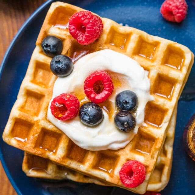 Classic Waffles on plate with whipped cream and berries