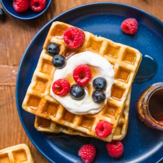 Classic Waffles on plate with whipped cream and berries