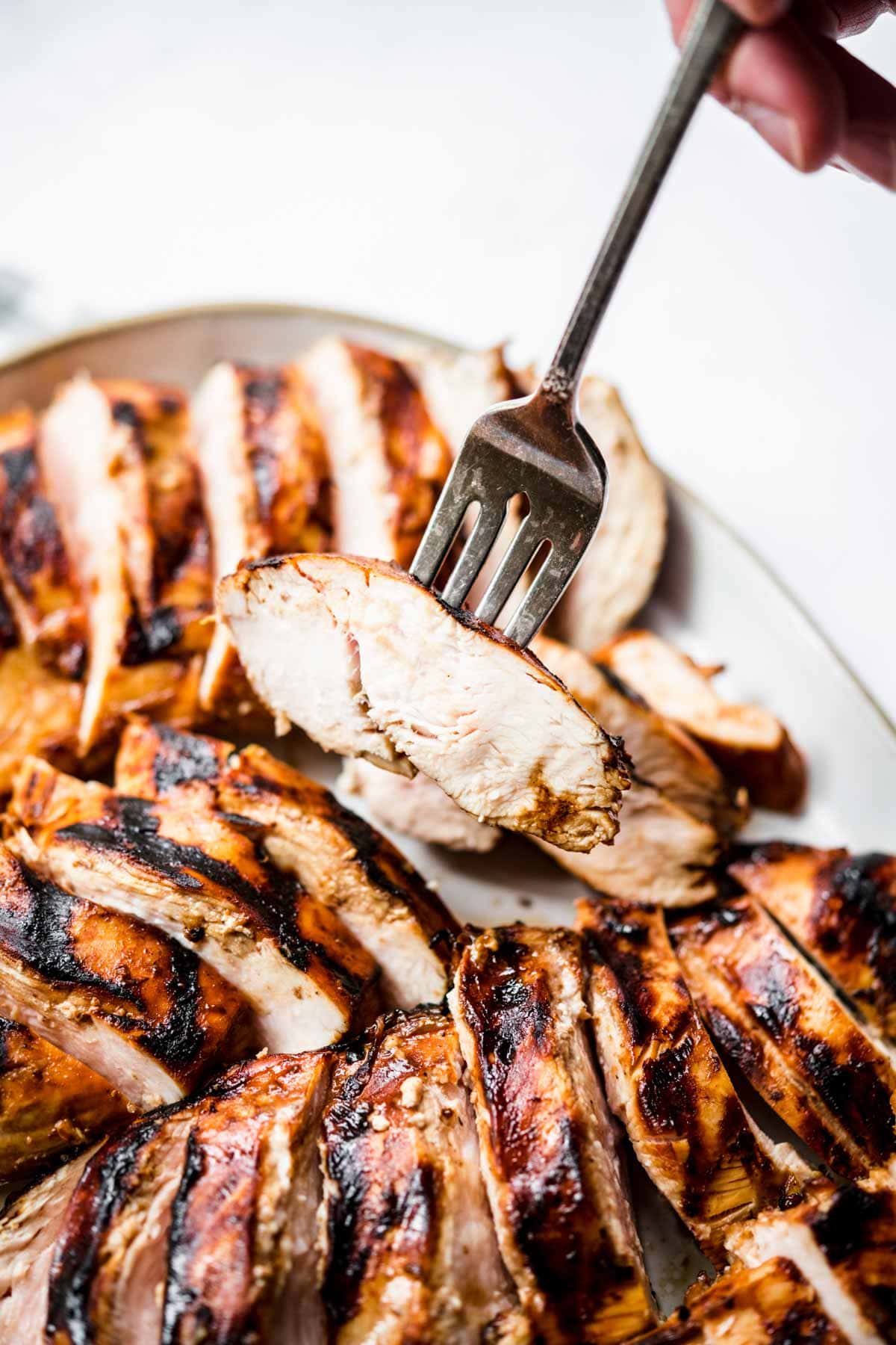 Grilled Chicken Marinade sliced chicken on plate with fork