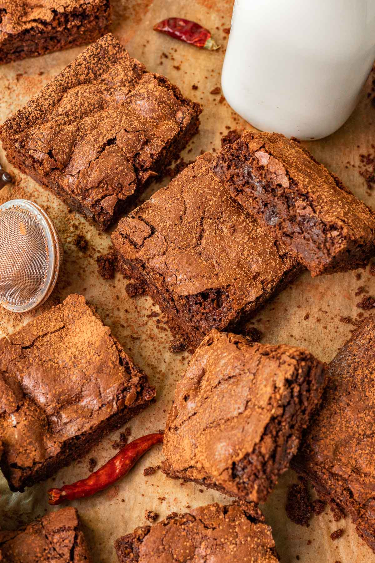 Mexican Brownies sliced close up on parchment paper with milk and cinnamon duster