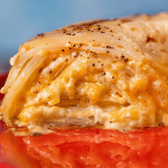 Side view of cross section of cheesy potatoes on a red platter