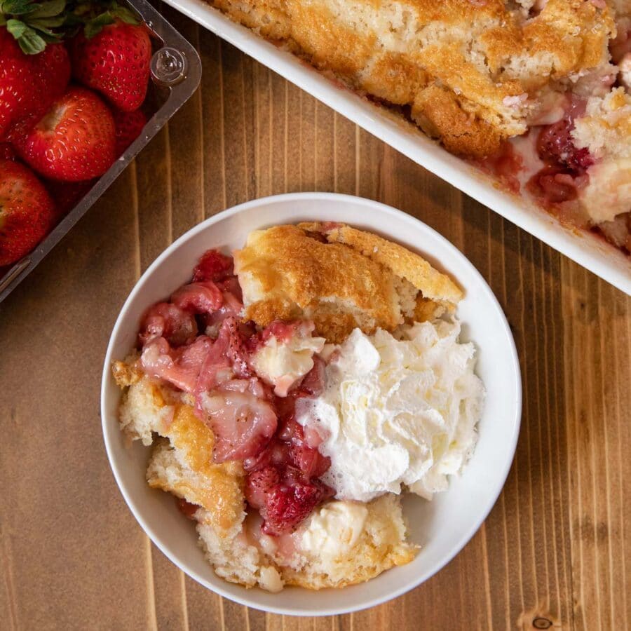 Strawberry Cream Cheese Cobbler serving in bowl with whipped cream