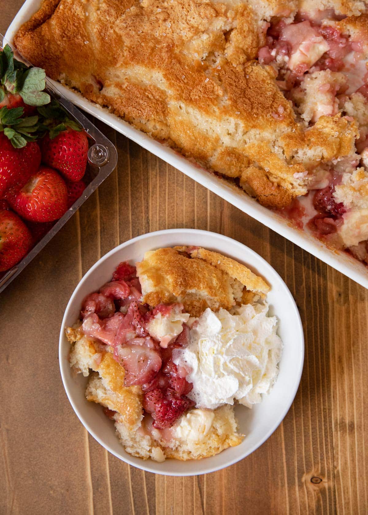 Strawberry Cream Cheese Cobbler serving in bowl with whipped cream