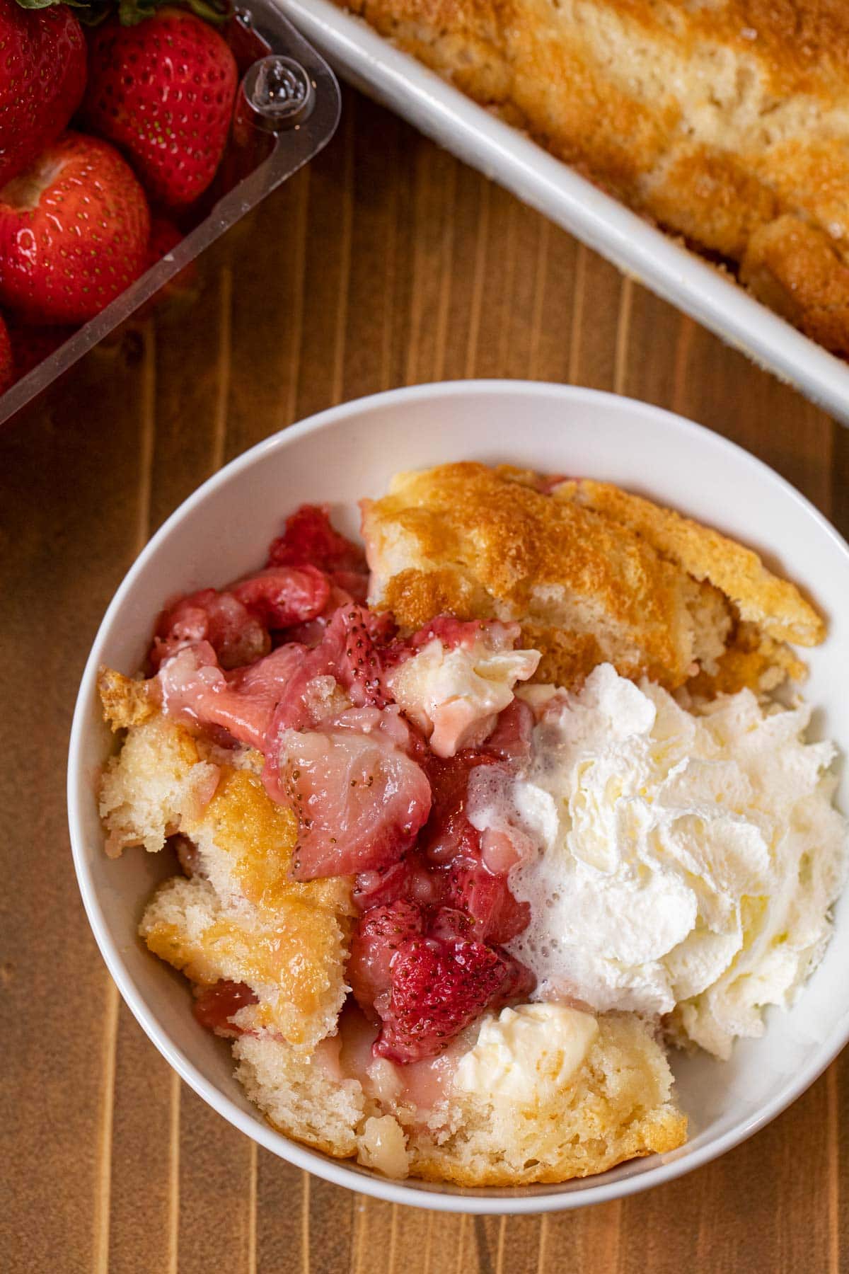 Strawberry Cream Cheese Cobbler serving in bowl with whipped cream