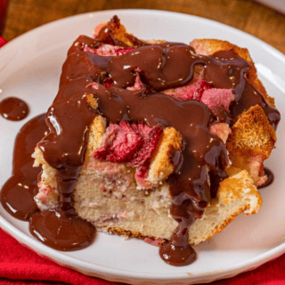 soggy bread on a plate with melted chocolate and strawberries