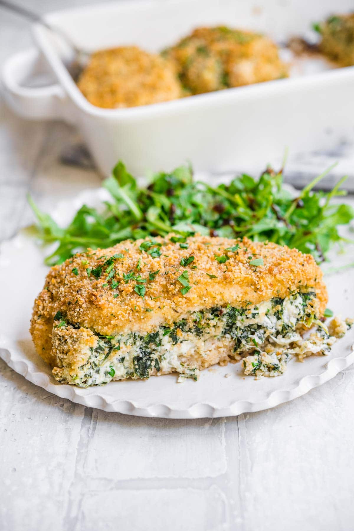 Stuffed Chicken Breast on dinner plate with salad