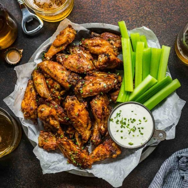 Baked Chicken Wings on serving plate with celery and creamy dip