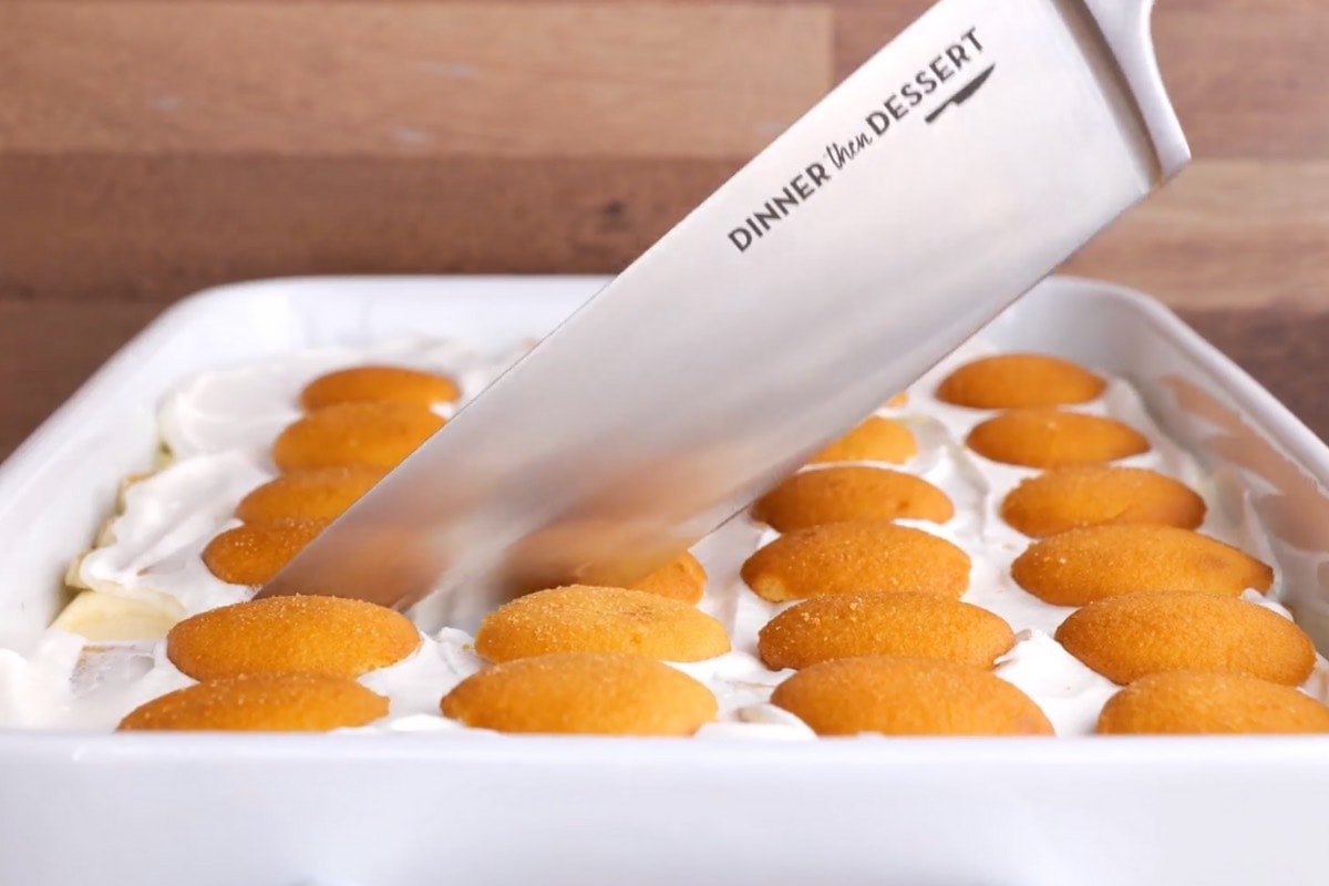 Banana Pudding in serving dish being cut with knife