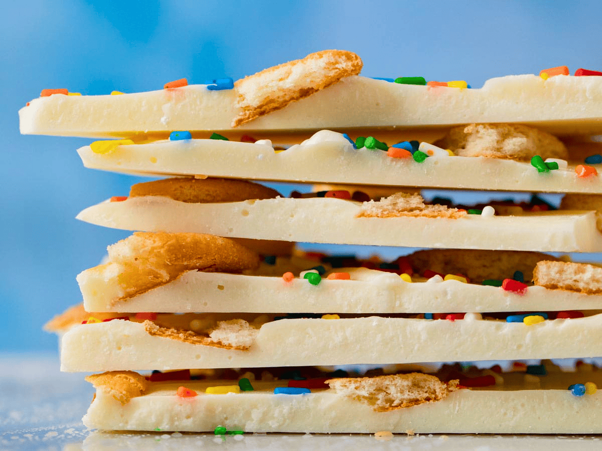 white chocolate with colored sprinkles and cookies on top stacked on one another
