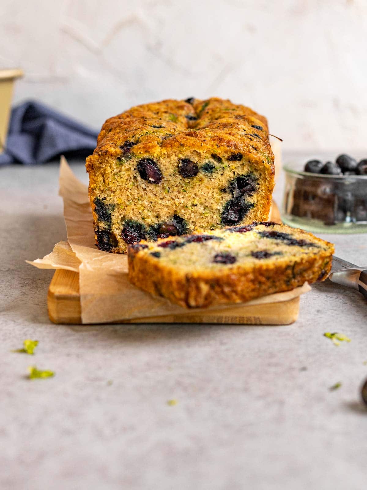 Blueberry Zucchini Bread loaf sliced on cutting board