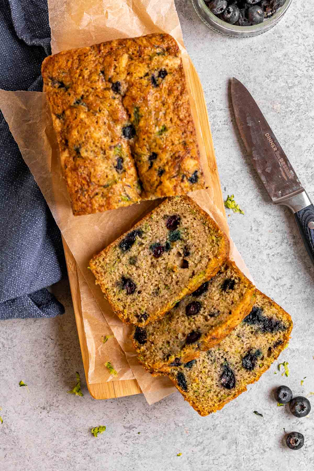 Blueberry Zucchini Bread loaf sliced on cutting board