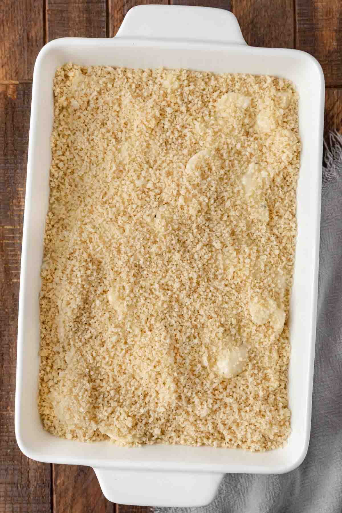 cauliflower florets covered with the cheese roux and bread crumbs in a baking dish